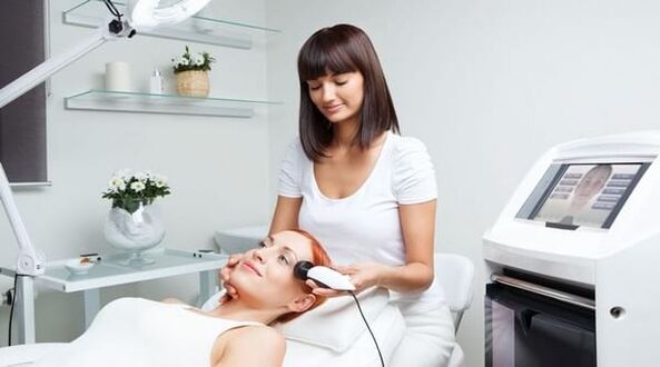 a specialist organizes a skin rejuvenation session with a device